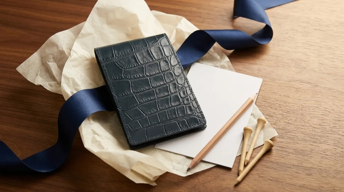 Luxury golf gift sets featuring a navy leather scorecard holder in a curated wrapped presentation